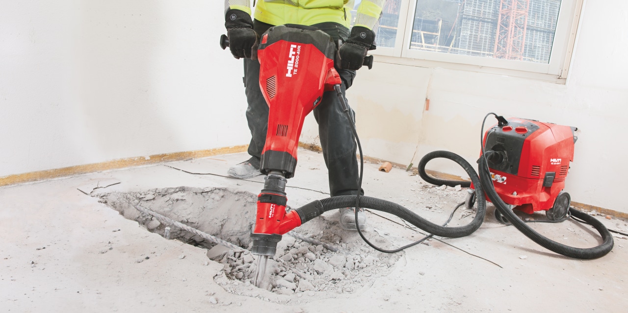 TE 2000-AVR concrete demolition hammer being used with a dust removal system and vacuum cleaner for virtually dust-free chiseling / breaking